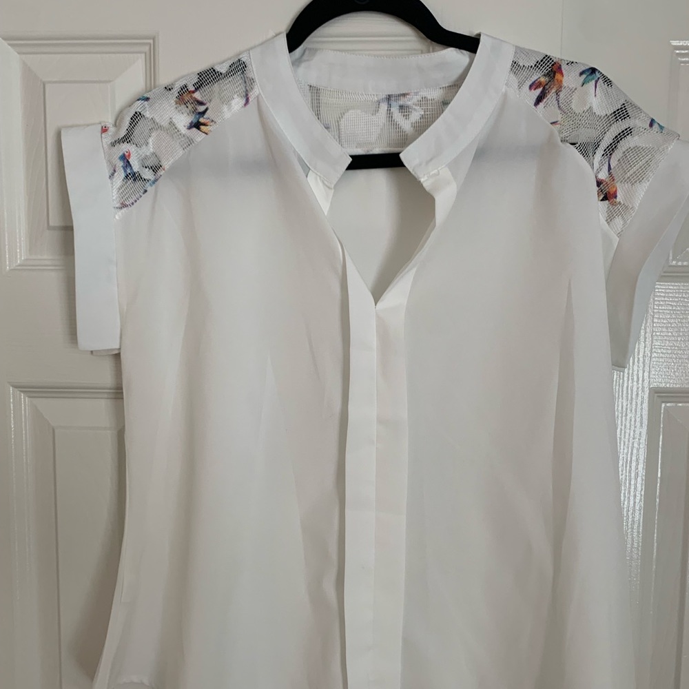 White blouse with rainbow colored bird pattern